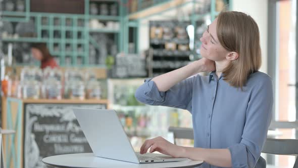 Young Woman Having Neck Pain While Typing on Laptop alt
