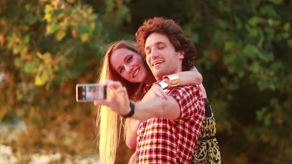 Cute young couple taking selfies and laughing alt