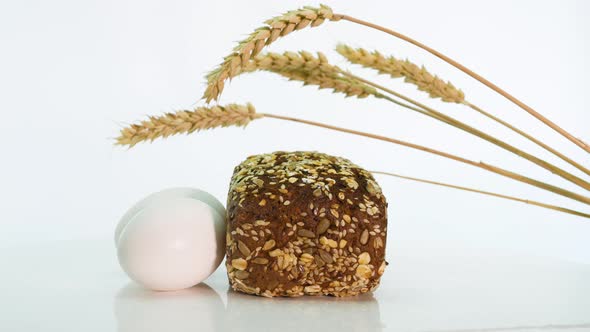 Bread Still Life On A White Background, Wheat Spikelets With Bread Spinning On The Table Isolated alt