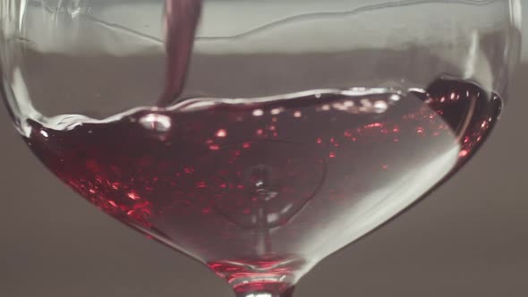 Close up Pinot Noir poured into glass slowly swirling around, Slow motion alt
