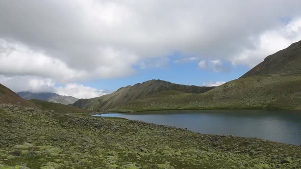Timelapse lake scenes in mountains with beautiful clouds moving fast in national park of Dombay