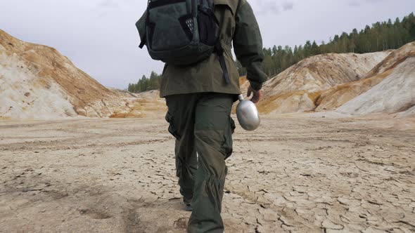An Unrecognizable Person Walks on Dry Cracked Lifeless Soil alt