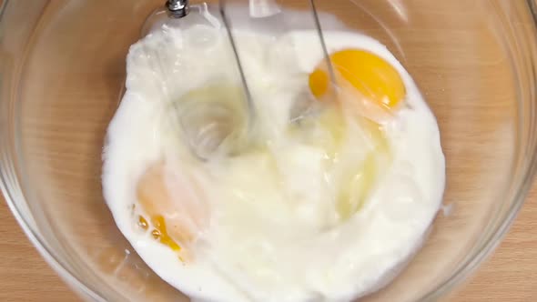 Ingredients for Omelet in Glass Bowl Whip Mixer. Slow Motion alt