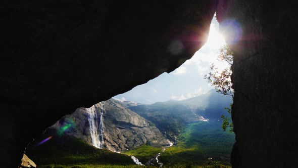 The Sun Shines Through the Arch in the Rock, Where You Can See the Picturesque Valley alt