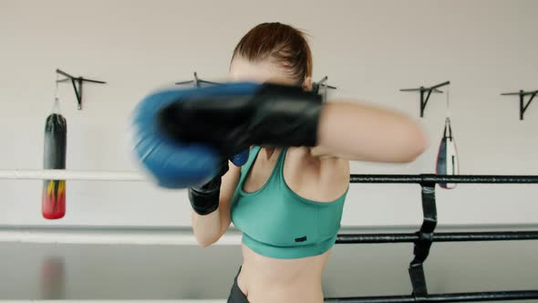 Portrait of Beautiful Young Boxer Wearing Gloves Fighting in Boxing Ring Winning Looking at Camera alt