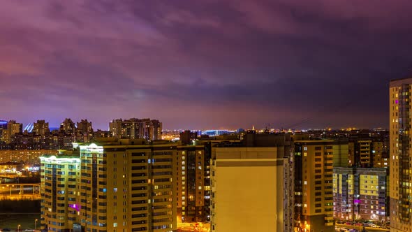 Evening lights in the buildings and on the streets, Timelapse. Beautiful clouds moves across the sky alt