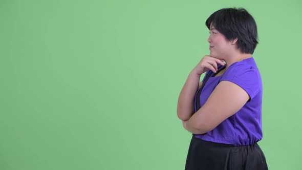 Profile View of Happy Young Overweight Asian Woman Thinking alt