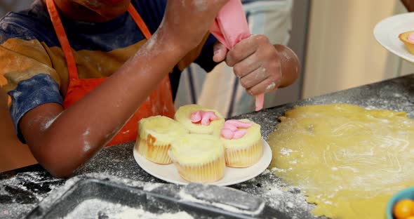 Mid section of boy preparing cupcake 4k alt
