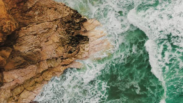 Sea Waves Beat Against Steep Cliff on Sunny Day Slow Motion alt