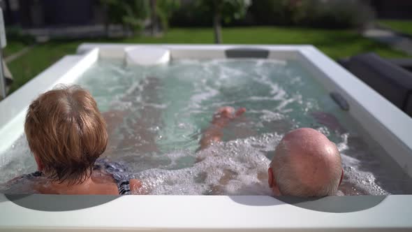 Senior Couple Relaxing in Whirlpool Outdoors
