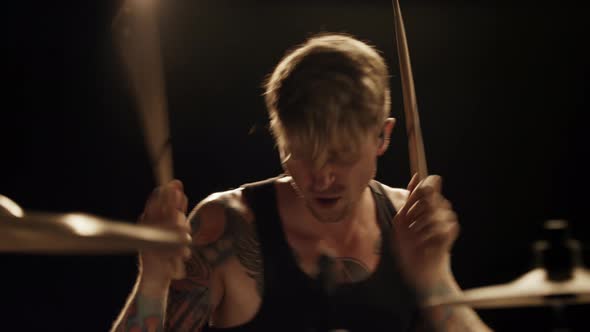 Caucasian Rock Musician Drummer with Tattoos Aggressively Plays Drums
