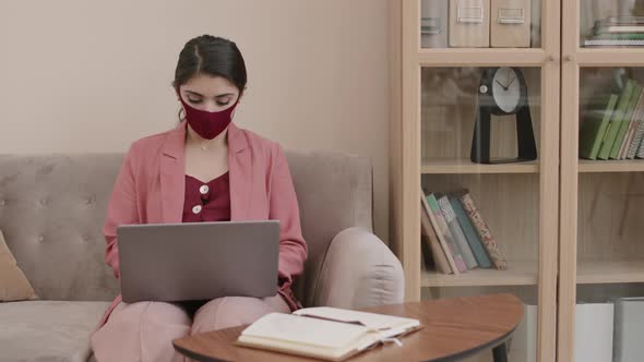 Mixed-race Businesswoman Wearing Mask Working on Laptop alt