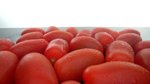Ripe Red Biological Tomatoes in a Row on a Smooth Glass Surface alt