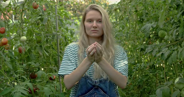 Woman Farmer Shows Tomatoes in Her Hands to the Camera