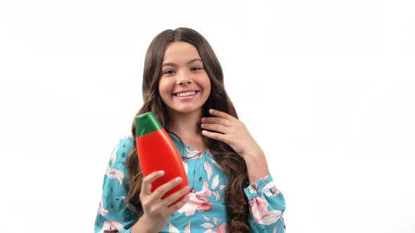 Happy Child Girl with Curly Hair Presenting Cosmetic Product for Teen Showing Thumb Up Haircare alt