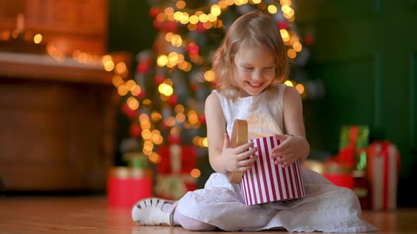 Happy Cute Little Girl opens a Christmas present