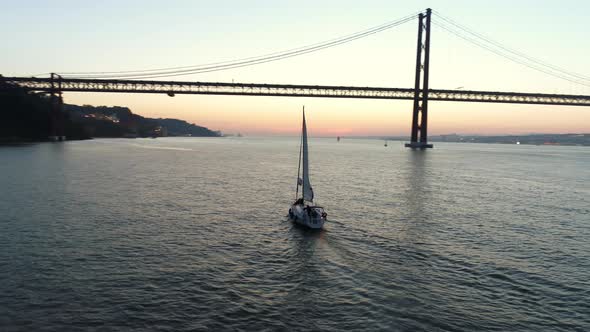 Aerial Footage Yacht and 25Th April Bridge in Twilight