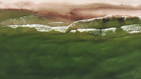 AERIAL: Flying very high over waves while they crash on the shore alt