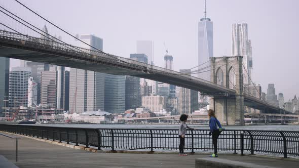 Joggers training outside in New York City with skyline and Brooklyn Bridge in background