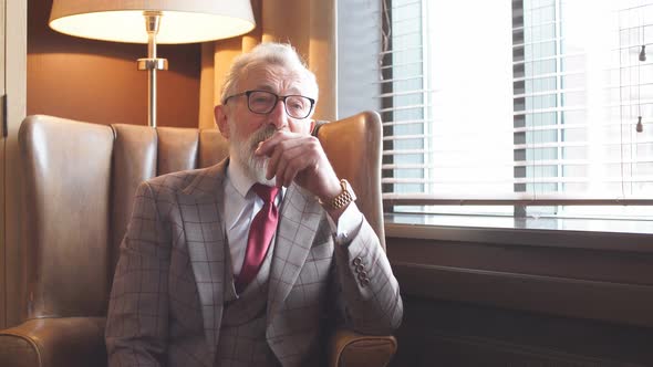 Toned Retro Styled Portrait of Businessman Sitting in Armchair at Office alt