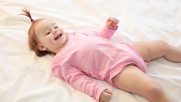 Pretty little girl playing and laughing on bed. Father play with daughter alt