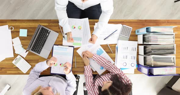 Business Team is Studying Analytic Charts and Holding Thumbs Up Top View alt