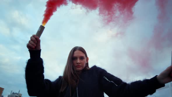 Woman Looking at Camera Through Smoke. Girl Using Smoke Bombs at Protest alt
