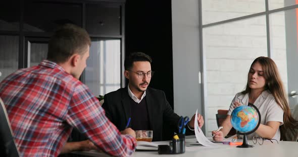 Creative Team of a Business Meeting in a Modern Starting Office Discussing Ideas for the Development alt