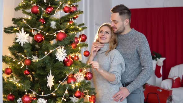 Couple Decorating the Christmas Tree Together in the Christmas Eve alt