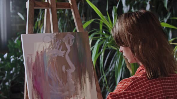 Young Woman Drawing an Abstract Painting on a Canvas alt