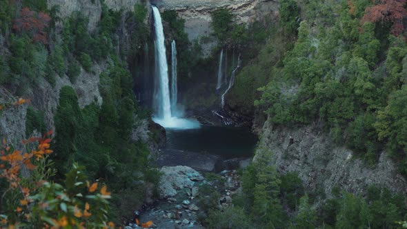 Establishing shot of a cascade with rocks and vegetation around in a national park of Chile alt