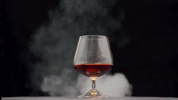 Strong Alcoholic Drink Whiskey Brandy Cognac in Glass with Smoke From Cigar alt