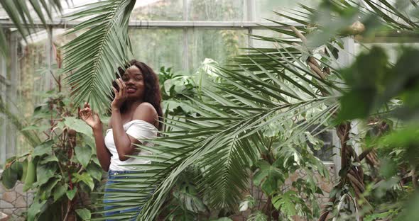 Beautiful Girl with Tanned Skin Holds Red Exotic Flower in Her Hands Being Among alt