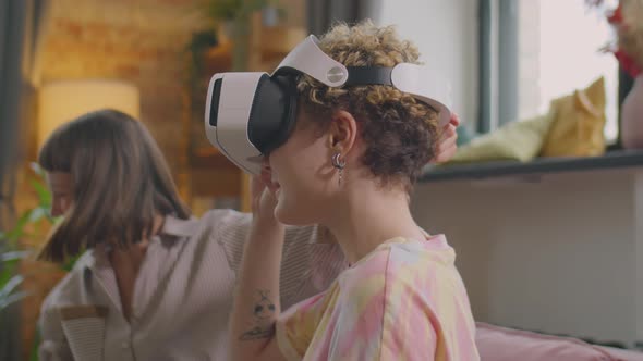 Joyous Girlfriends Using VR Headset at Home alt