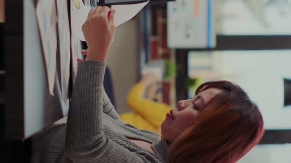 Vertical Video Office Worker Using Documents and Laptop to Plan Leadership Presentation alt