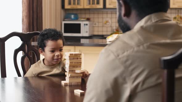 African American little boy starting to play Jenga with his father