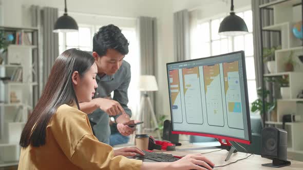 Asian Male And Beautiful Female Mobile Application Designers Test And Discuss New App Features alt