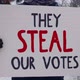 Protestor standing with banner with black and red writing They Steal Our Votes. - VideoHive Item for Sale