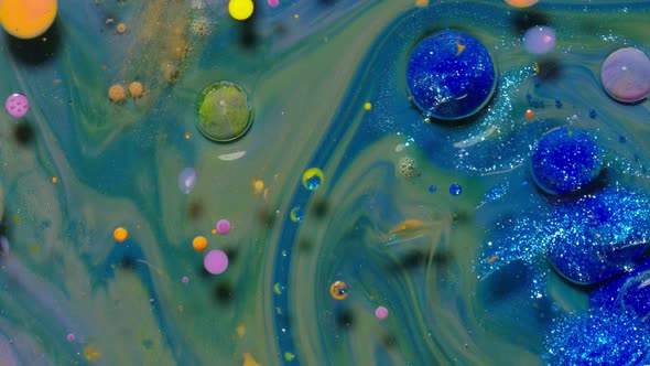 Top View Movement of Blue Oil Ink Drops Bubbles Multicolored Artistic Paint Surface Background alt