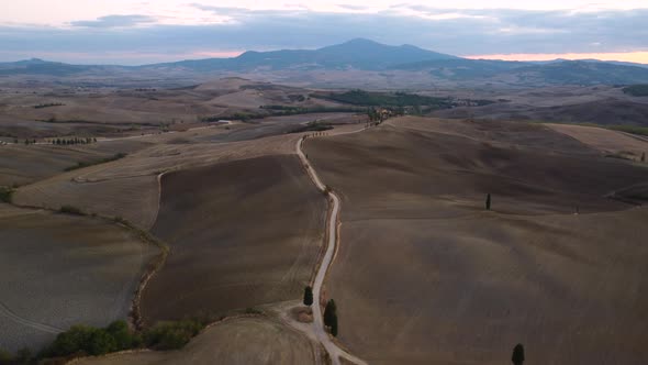 Val d'Orcia Cypress Trees Road and Farmhouse in Tuscany Aerial View alt