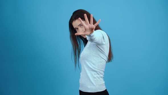 The Annoyed Girl Aggressively Extends Her Hand Forward Shows an Aggressive Stop with Her Fingers alt