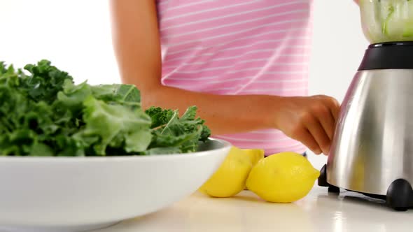 Woman preparing vegetable smoothie alt
