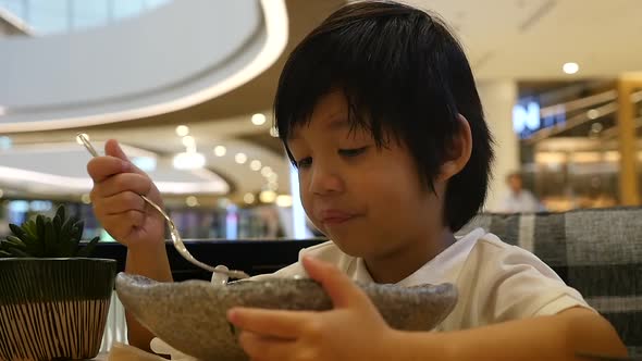 Cute Asian Child Eating Japanese Noodles In A Restaurant Slow Motion alt