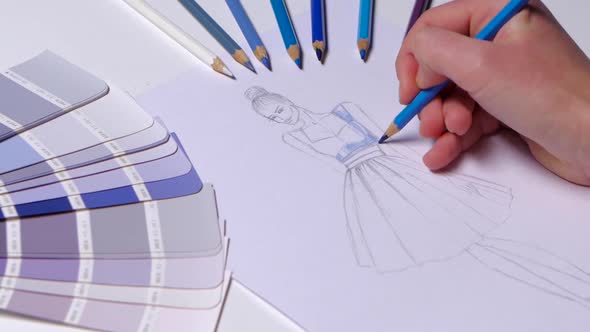 Designer Dress Decorates a Sketch in Blue, on a Table Cloth Samples Lie. Close Up alt