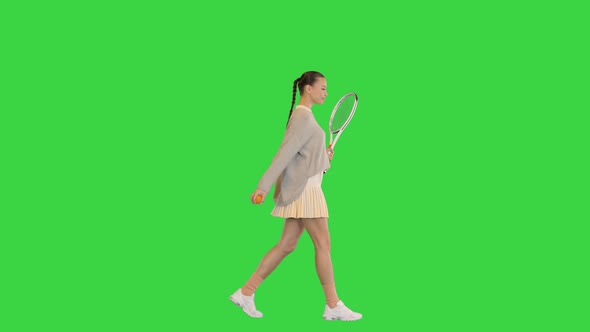 Female Tennis Player Walking and Tossing a Ball Up on a Green Screen Chroma Key