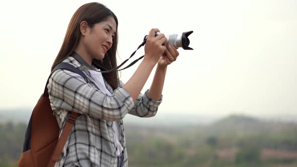 tourist woman taking a photo with her camera in nature