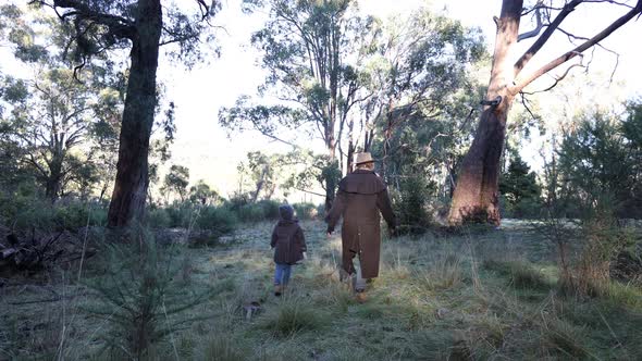 A bushman and his son walk through the bush on a cold morning in the Australian high country. alt