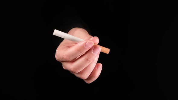 A hand with a cigarette appears from the darkness, as if offering to smoke alt