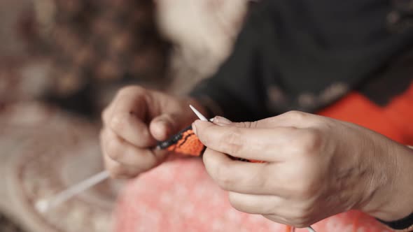 Close up of woman's hands knitting with two needle crafts and red wool. 4k Footage of knit work tie- alt