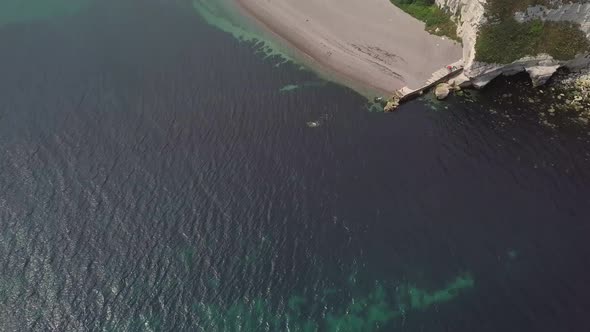 Beautiful revealing shot of Beer, England, Aerial. Ocean, shore, town, countryside. alt